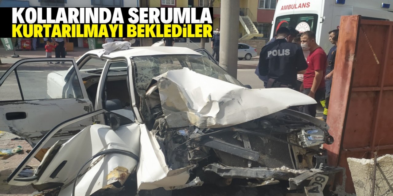 Kaza yaptıkları otomobilde sıkışan iki kardeş, kollarında serumla kurtarılmayı bekledi