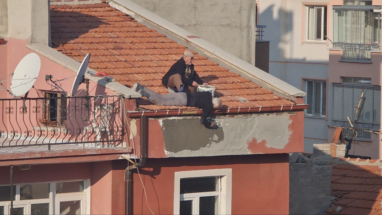 Konya'da  bir vatandaş 4 katlı  binanın çatısından sarkarak sıva yaptı