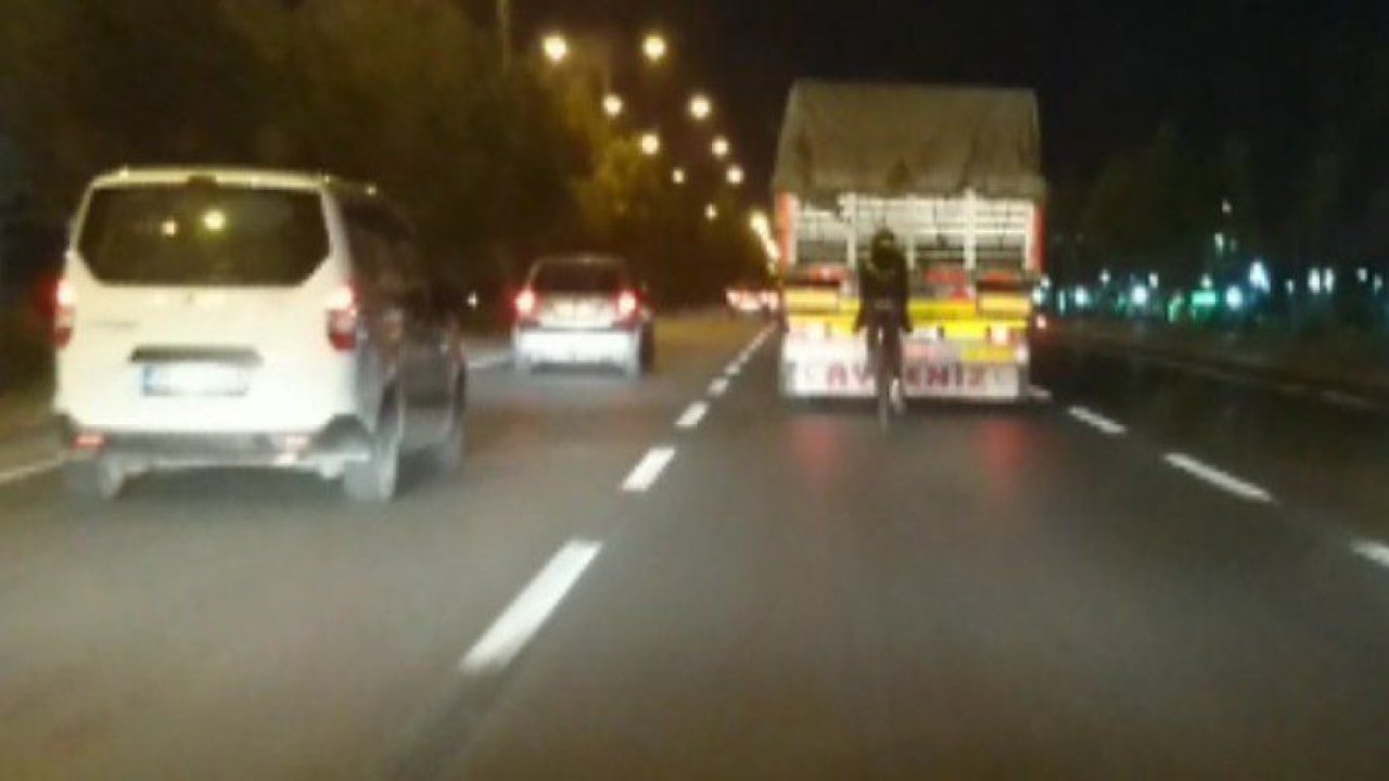 Tehlikeye aldırış etmeden bisikletiyle kamyonun arkasında seyretti