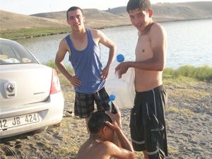 Yüzdükten sonra bidonlarla duş alıyorlar