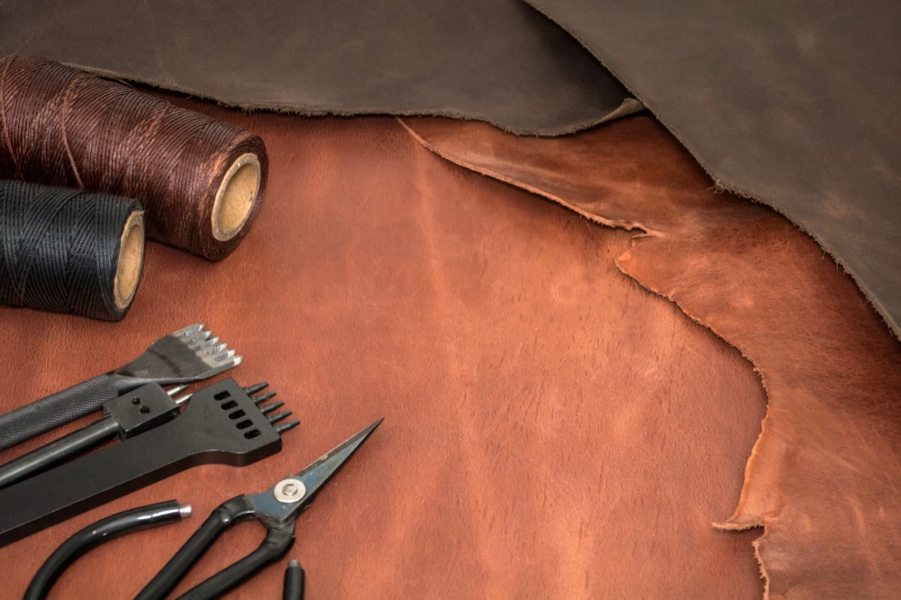 tools-for-leather-crafting-and-pieces-of-brown-leather-manufacture-of-leather-goods-view-from-above-flat-lay-empty-space-for-text-e1675267642854.webp